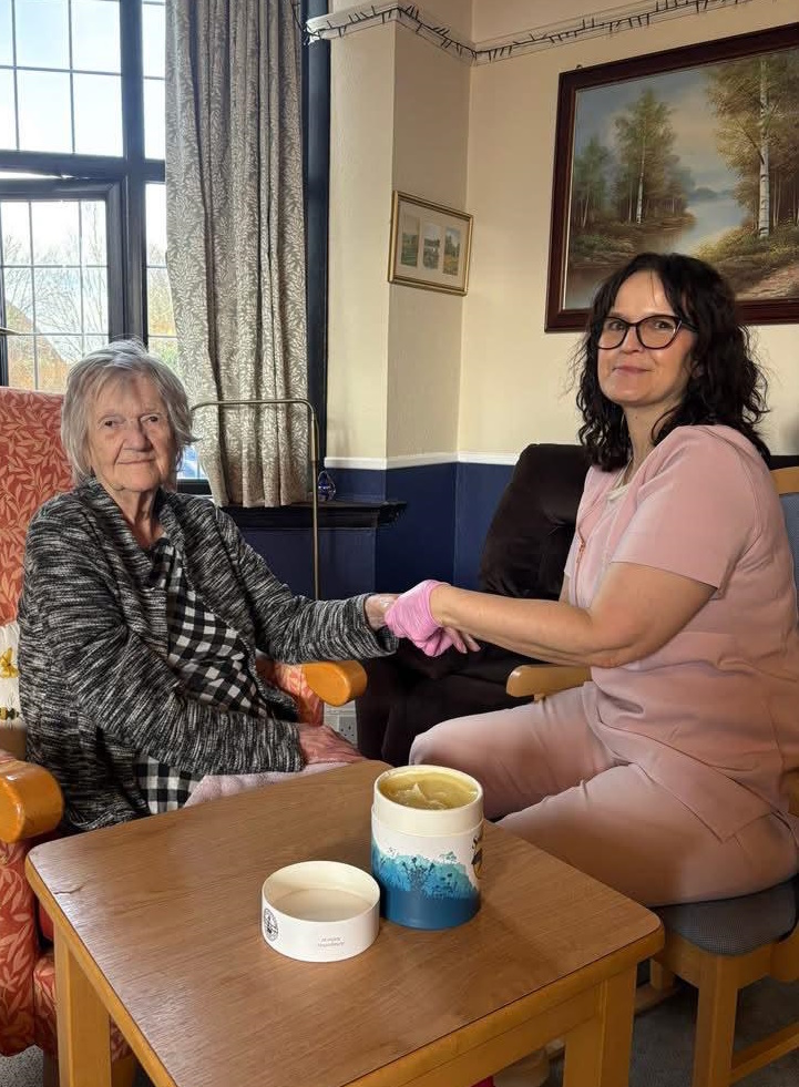 A therapist gently massaging an older person's hand