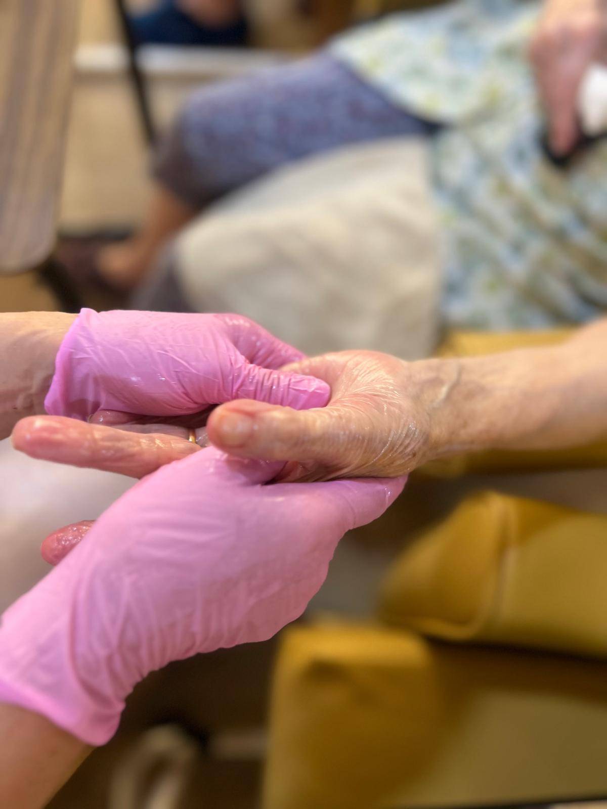An older person's hands held gently during a massage